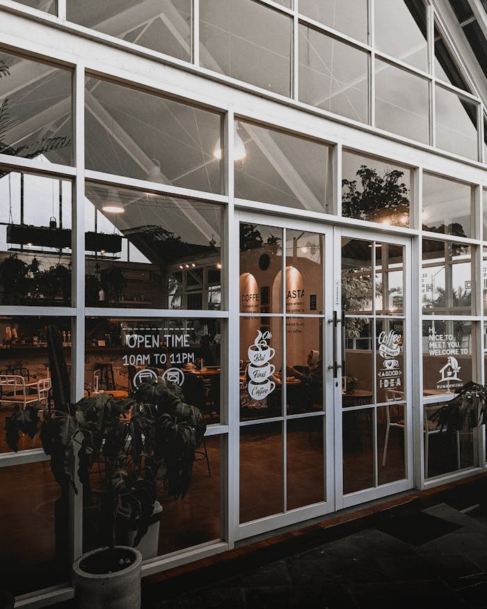 Stylish café entrance in Serang, Indonesia, featuring glass doors and modern design.