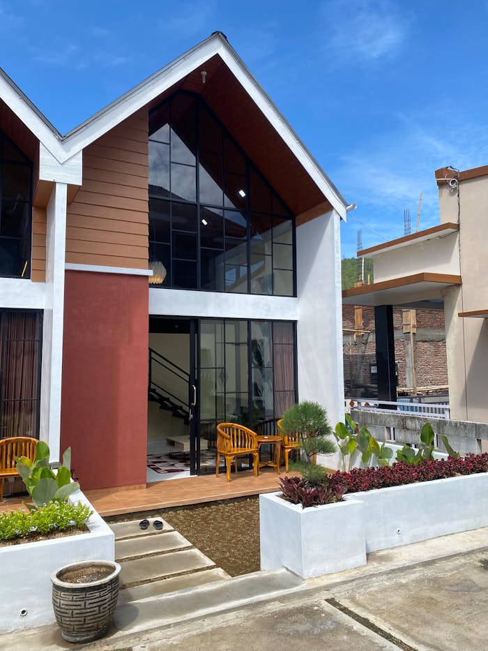 Contemporary townhouse featuring large windows, wooden accents, and a small front garden.